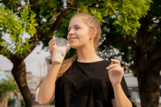 Young beautiful cute Brazilian female drinking Somo, a Bolivian drink