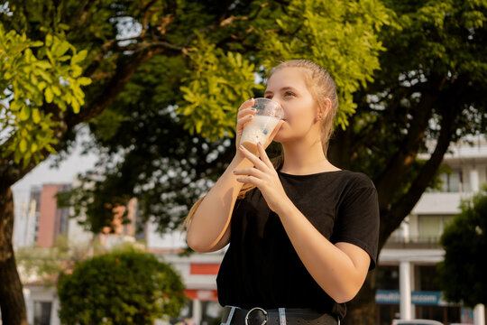 Young beautiful cute Brazilian female drinking Somo, a Bolivian drink