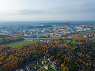 Drone view of the village, part of the city and beautiful autumn forest. Beautiful landscape, urban area and village