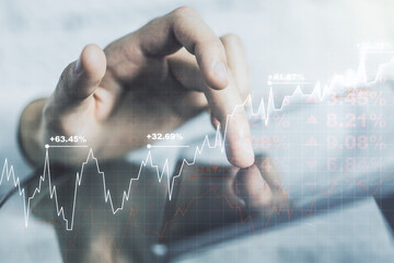 Abstract creative financial graph with finger clicks on a digital tablet on background, financial...