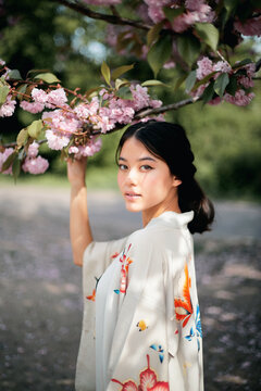 Portrait of woman holding branch of tree
