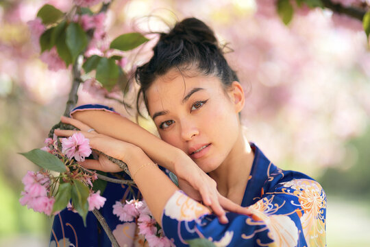 Portrait of woman leaning on branch