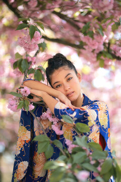 Portrait of woman leaning on branch