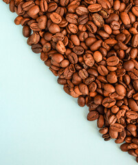 Roasted coffee beans arranged diagonally isolated on a light background. Background and texture of coffee. Copy space.