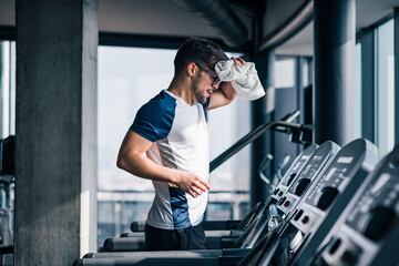 Portrait of muscular sportsman training at modern gym.