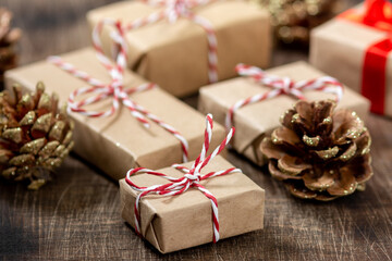 Gift boxes in Kraft paper. Christmas background. Christmas gift boxes on brown wooden background. Christmas or new year gift close up
