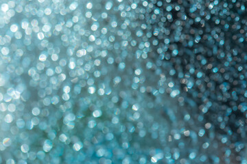 Abstract blue shiny background with bokeh. The concept of the winter holidays. Aquamarine glitter texture with silver blurred background. Design concept for decorations, holiday, Wallpaper, Christmas.