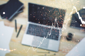 Double exposure of abstract creative financial chart with world map on laptop background, research and strategy concept