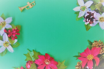 Christmas composition: frame of poinsettias, fir, candy cane, pinecones and a golden trumpet on a green background