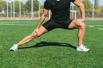 Mature fitness man stretching on grass field. Close up. Lifestyle and sports