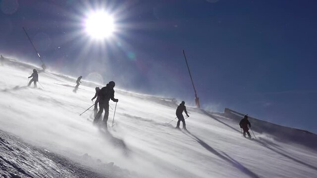 Skiers on a Ski Slope With a Blizzard on a Sunny Day. Slow Motion