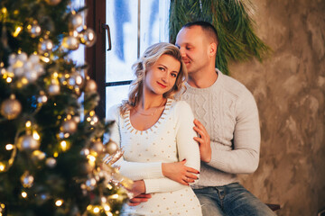 lovers cuddle near the winter window