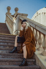 Outdoor full-length fashion portrait of young elegant woman wearing trendy brown faux fur coat,...