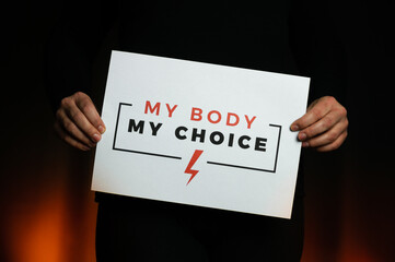 Woman holding a sign "My Body, My Choice". Protest against tightening of the abortion law in Poland. Nationwide women's strike. Wearing mask against COVID-19 Coronavirus.