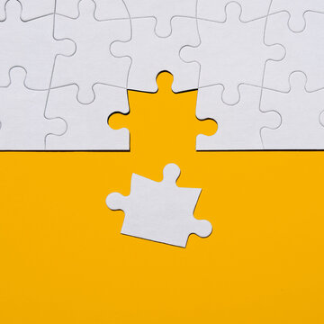 Last puzzle piece in jigsaw puzzle on yellow background