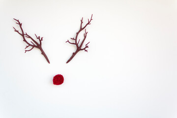 Christmas reindeer concept with red nose and antlers on white background with copy space