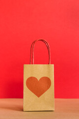 Valentine's Day concept. Shopping paper bag with heart print on red background. 
