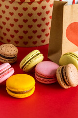 Sweet French colorful macarons on red background. Valentines Day concept. 