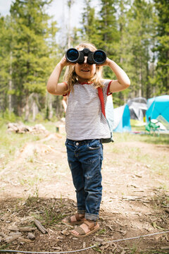 Girl (4-5) looking through binoculars in forest, Wasatch-Cache National Forest