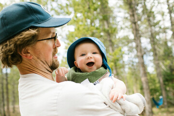 Father holding baby son (6-11 months) in forest, Wasatch-Cache National Forest