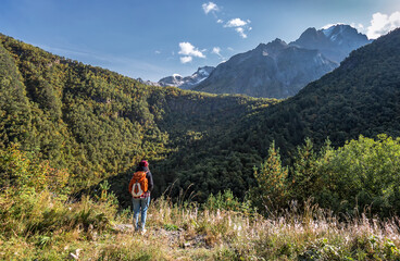 Fototapeta na wymiar A tourist looks into the distance at the mountain peaks