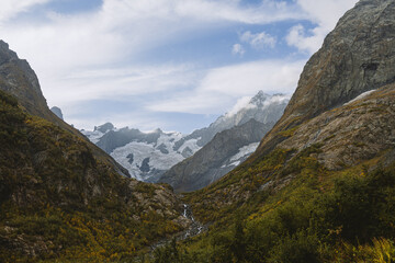 Obraz premium River canyon in mountains. Valley of river and glacier. Beautiful background of Caucasus mountains.