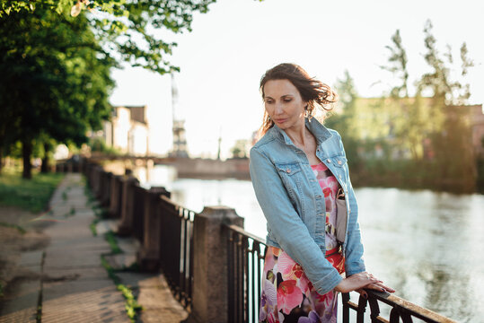 Beautiful aged woman posing on the river embankment.