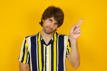 No sign gesture. Closeup portrait unhappy Young handsome Caucasian man, wearing stripped shirt...