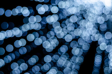 Festive blurred background of glowing garlands on the streets of the city for Christmas and New Year.