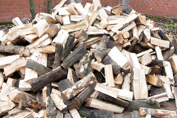 Heap of chopped firewood. Pile of split firewood. Stack of fuel wood