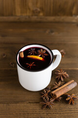 A mug of hot red mulled wine with spices, cinnamon, orange and star anise. Christmas hot drink. Holiday atmosphere