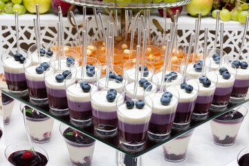 Assorted mini desserts in a cup with a spoon. berry milk, creamy desserts in a cup