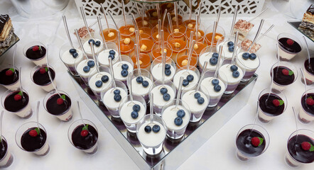 Assorted mini desserts in a cup with a spoon. berry milk, creamy desserts in a cup