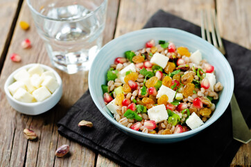 Barley pomegranate raisins feta salad in a bowl