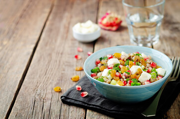 Barley pomegranate raisins feta salad in a bowl