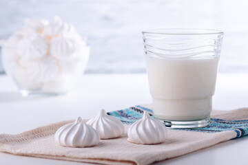 Natural whole milk in a jug and glass with bizet on a white brick wall background