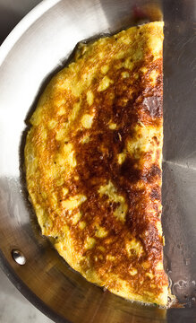 Overhead view of spinach and garlic omelet in pan