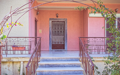 contemporary house entrance marble stairs to metallic framework door and pink wall