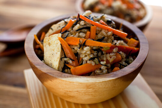 Close up of brown rice bowl with carrot and hijiki served on table
