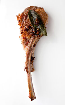 Close up of fried lamb chop with anchovies and capers served on plate