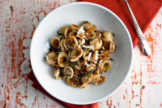 Overhead view of orecchiette with grated squash, walnuts and ricotta salata