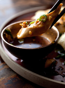 Close up of sake steamed chicken dipped in sauce