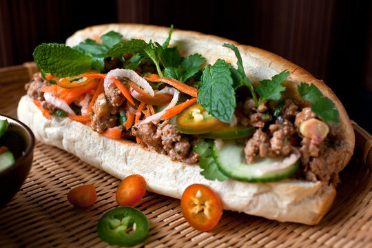 Close up of banh mi with pickled carrots and daikon served on plate