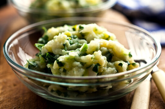 Close up of mashed turnips and potatoes with turnip greens served in bowl