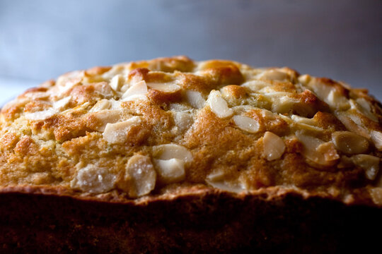 Close Up Of Coconut Oil Pound Cake Topped With Almonds And Lime Zest