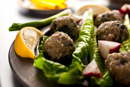 Close up of red lentil kofta with spinach served on cutting board