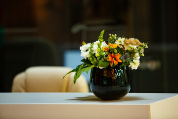 Working table with vase of flowers in modern office. Bouquet of flowers on a table in a modern room.