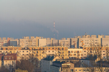 Air pollution visible against chimney and housing estate in Cracow