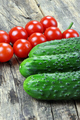 Cherry tomatoes and cucumbers on a wooden background. Vegetables on a old wooden table. Healthy food. Vegan food