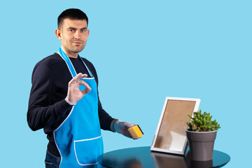 A handsome man in an apron and gloves, wipes off his ardor and looks contentedly at the camera....